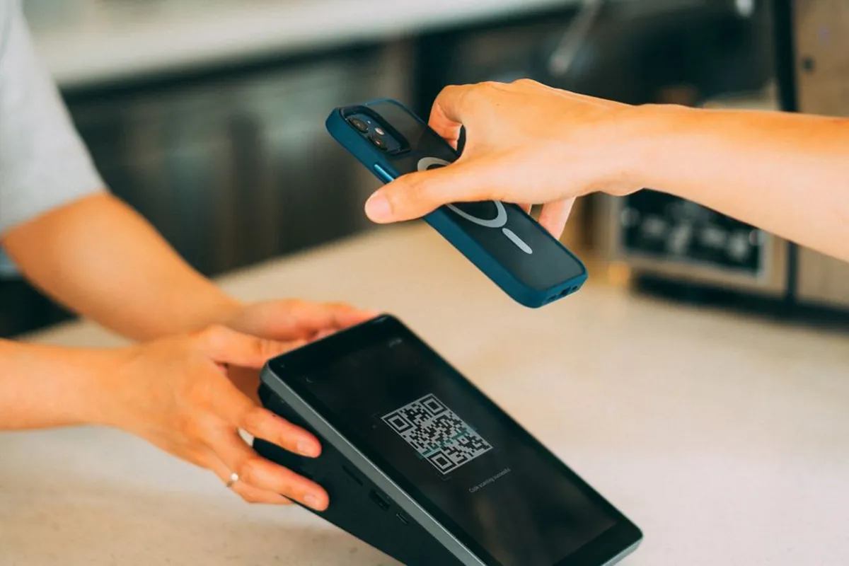 Celular conferindo pagamento por QR Code